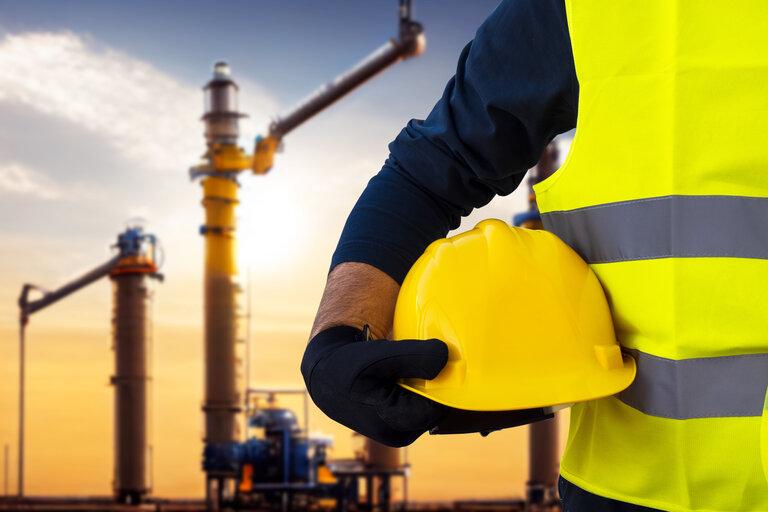 Bauarbeiter-Ingenieur auf dem Hintergrund einer im Bau befindlichen Gasanlage, eines Erdgasfeldes, einer Gaspumpstation.
