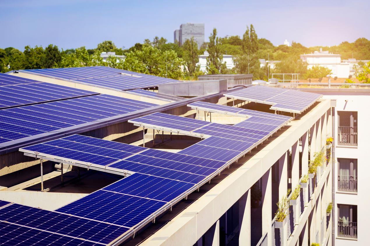 Glas-Glas-Photovoltaik-Module auf einem Flachdach eines Mehrfamilienhauses, optimiert für maximale Energieeffizienz und Langlebigkeit.

